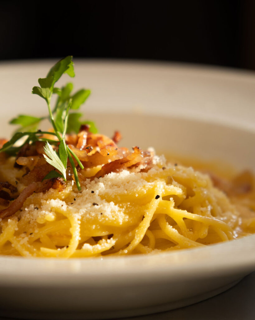 Assiette de spaghetti carbonara servie à la brasserie italienne Le Palmarès à Spa, cuisine authentique et généreuse préparée par un chef expérimenté
